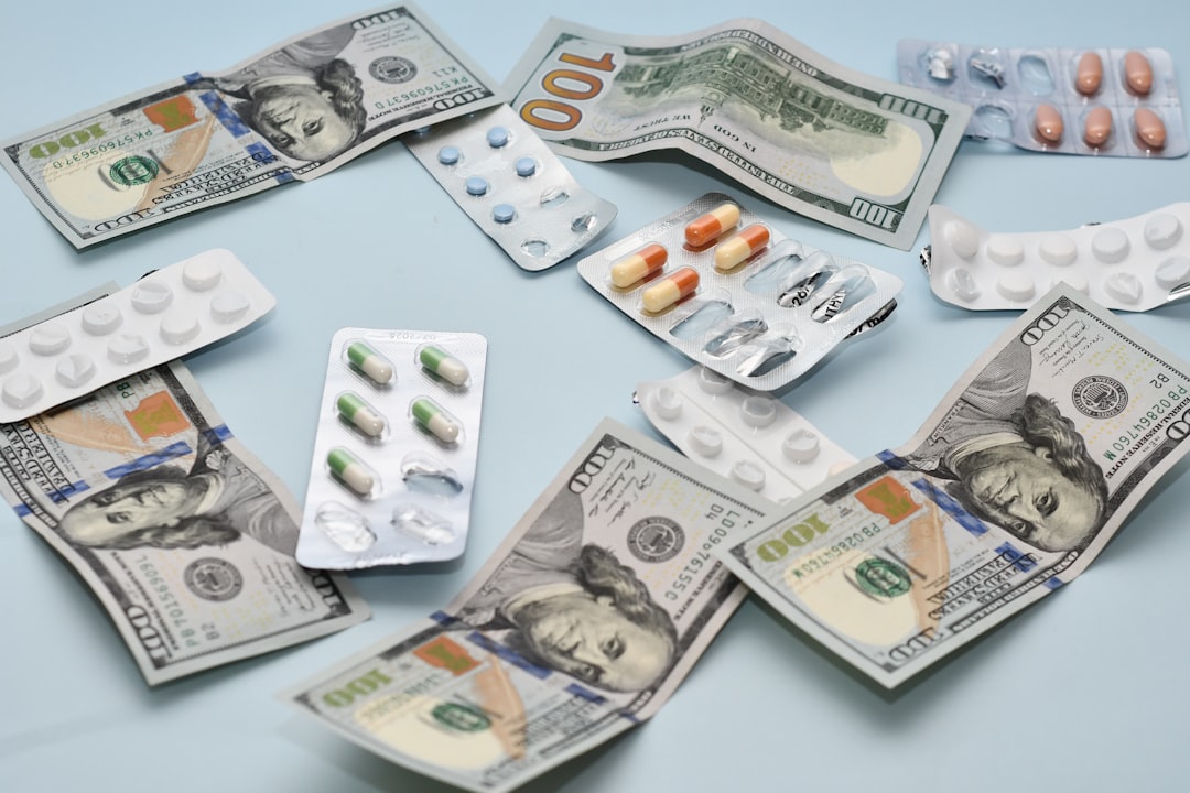 Diverse assortment of prescription medications placed around dollar bills on a light blue background