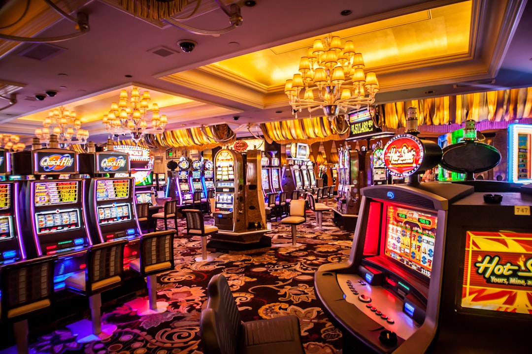 Interior view of a brightly lit casino with multiple slot machines and tables